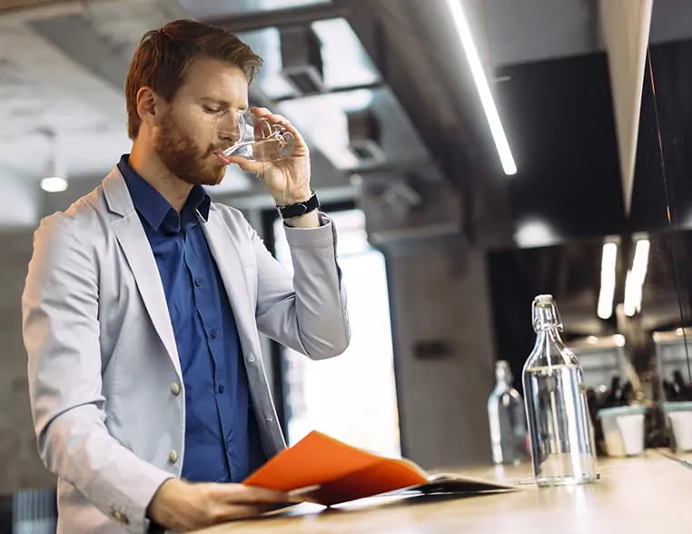 Mann trinkt Leitungswasser aus Glas; Thema: Warum riecht Trinkwasser nach Chlor?